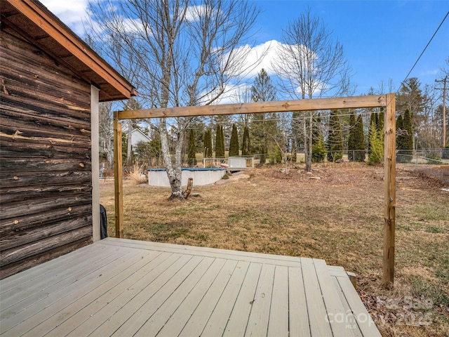 wooden deck featuring a fenced in pool and a yard