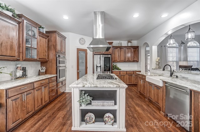 kitchen with sink, appliances with stainless steel finishes, a kitchen island, island exhaust hood, and decorative backsplash