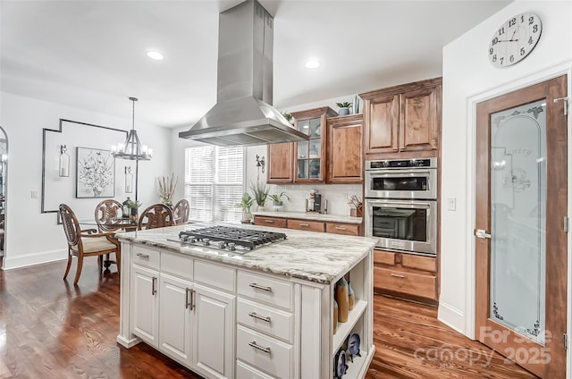 kitchen featuring appliances with stainless steel finishes, a kitchen island, white cabinets, island exhaust hood, and backsplash