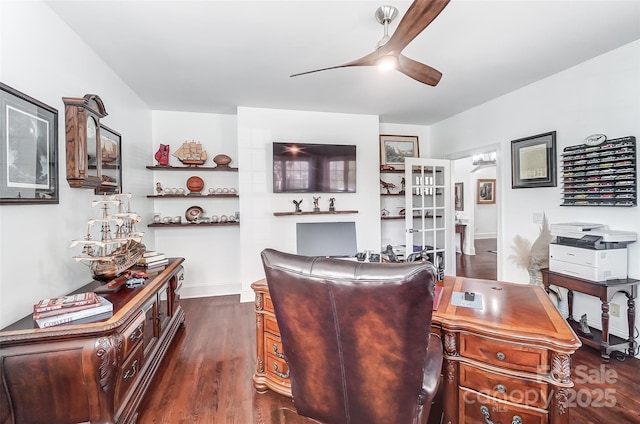 home office with dark wood-type flooring and ceiling fan