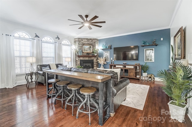 living room with dark hardwood / wood-style floors, ceiling fan, a fireplace, and a wealth of natural light