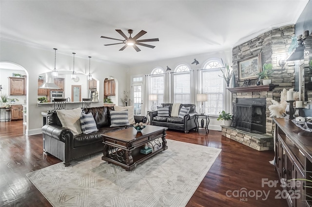 living room featuring ceiling fan, wood-type flooring, and a fireplace