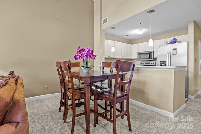 carpeted dining room featuring a textured ceiling