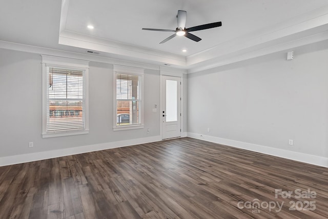 interior space with a raised ceiling, ornamental molding, ceiling fan, and dark hardwood / wood-style flooring