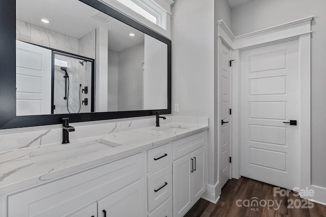 bathroom with vanity, a shower with shower door, and hardwood / wood-style floors