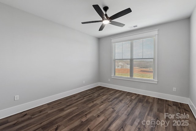 empty room with ceiling fan and dark hardwood / wood-style flooring