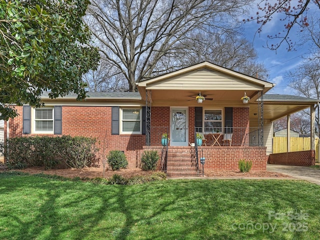 view of front of property featuring ceiling fan, covered porch, brick siding, a carport, and a front yard