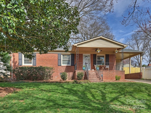 view of front facade featuring concrete driveway, an attached carport, a front lawn, a porch, and brick siding