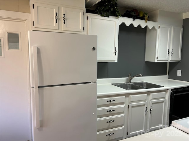 kitchen featuring sink, a textured ceiling, white refrigerator, black dishwasher, and white cabinets