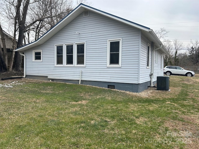 view of side of home with cooling unit and a lawn