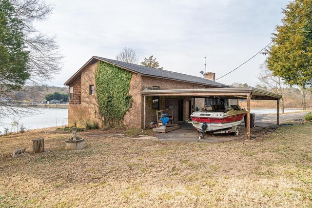 view of home's exterior with a lawn and a water view