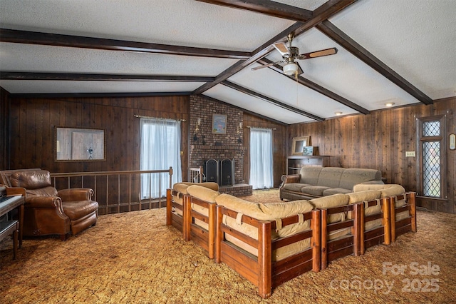 carpeted living room with a brick fireplace, lofted ceiling with beams, a textured ceiling, and wood walls