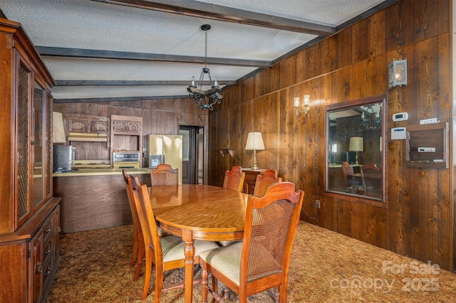 dining area with lofted ceiling with beams, dark carpet, wooden walls, and a textured ceiling