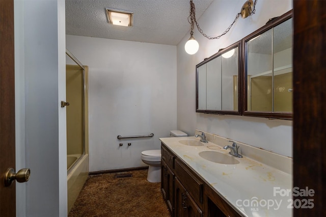 full bathroom featuring bath / shower combo with glass door, vanity, a textured ceiling, and toilet