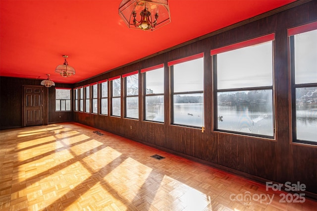 unfurnished sunroom featuring a chandelier