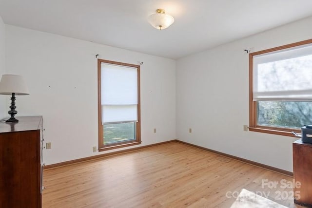 empty room with a healthy amount of sunlight and light hardwood / wood-style floors