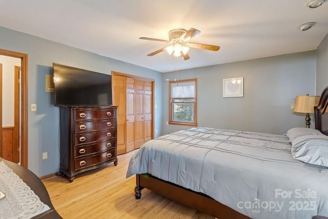 bedroom with light hardwood / wood-style flooring, a closet, and ceiling fan