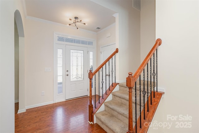 foyer entrance featuring crown molding and wood-type flooring