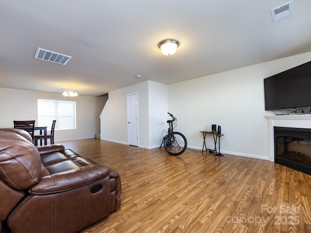 living room featuring an inviting chandelier and light wood-type flooring