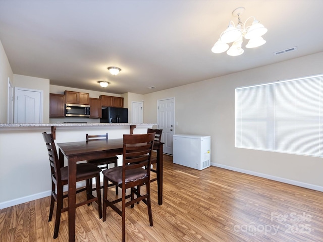 dining area featuring an inviting chandelier and light wood-type flooring