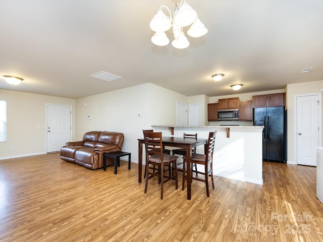 dining room featuring a chandelier and light wood-type flooring