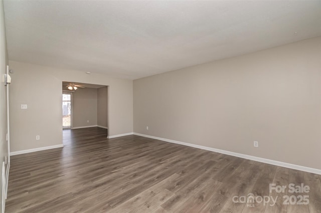 empty room featuring ceiling fan and dark hardwood / wood-style flooring