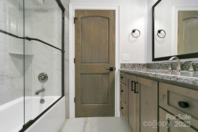 bathroom featuring vanity and shower / bath combination with glass door