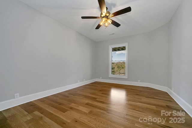 spare room with hardwood / wood-style floors and ceiling fan