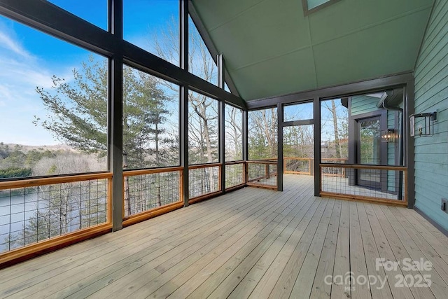 unfurnished sunroom featuring vaulted ceiling and a healthy amount of sunlight