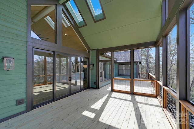 unfurnished sunroom featuring lofted ceiling with skylight