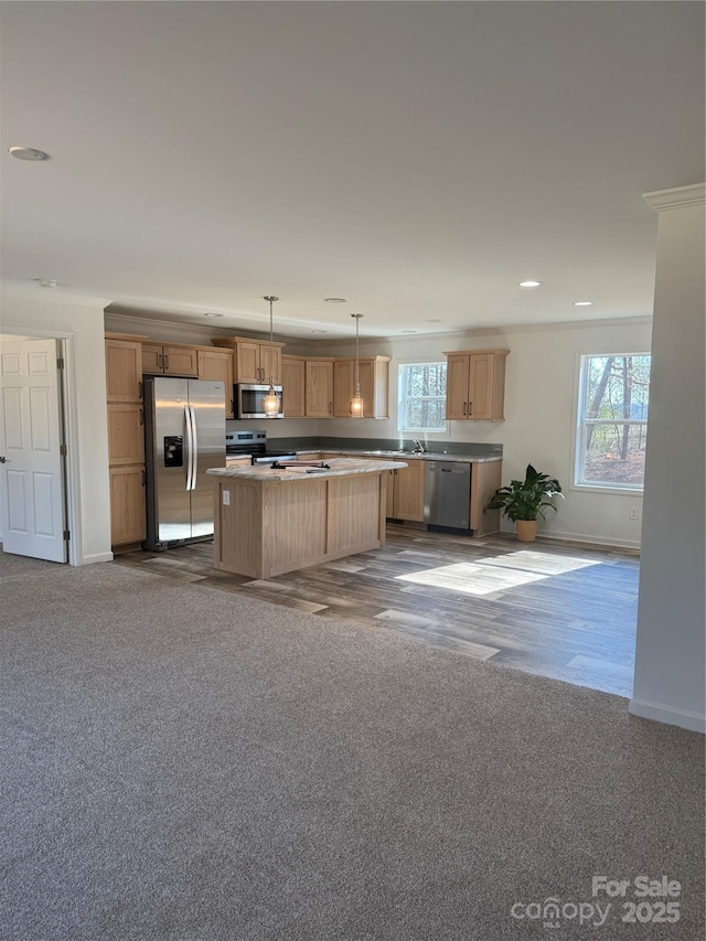 kitchen with pendant lighting, plenty of natural light, stainless steel appliances, and a kitchen island