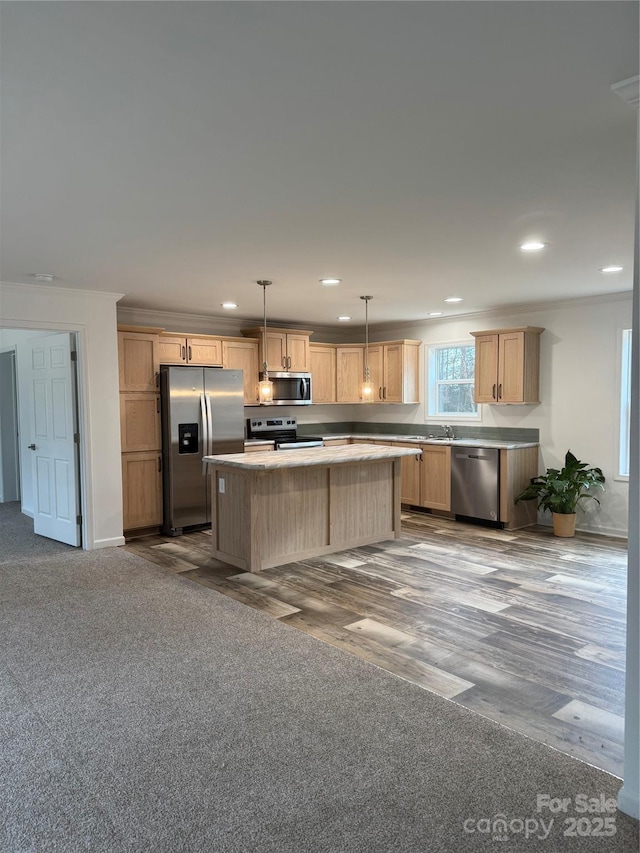 kitchen featuring sink, hanging light fixtures, light brown cabinets, appliances with stainless steel finishes, and a kitchen island