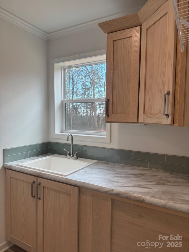 kitchen featuring ornamental molding, sink, and light brown cabinetry