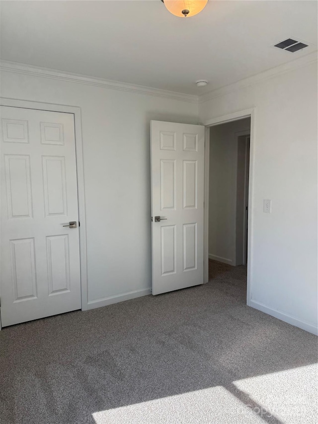 spare room featuring crown molding and carpet