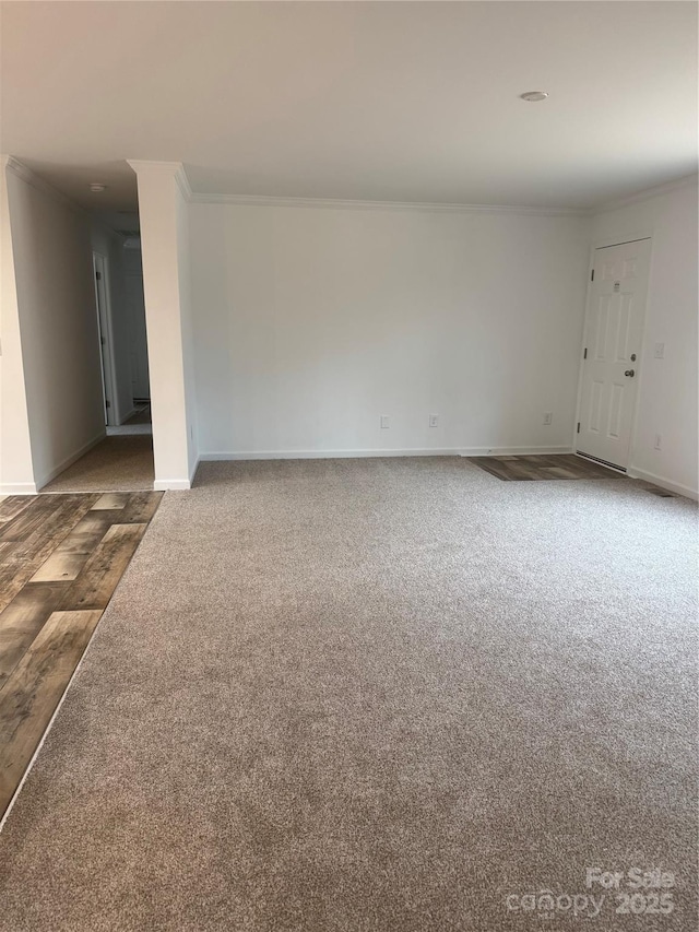 spare room featuring crown molding and dark colored carpet