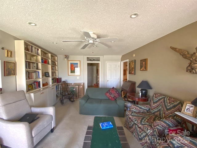 carpeted living area with a ceiling fan and a textured ceiling