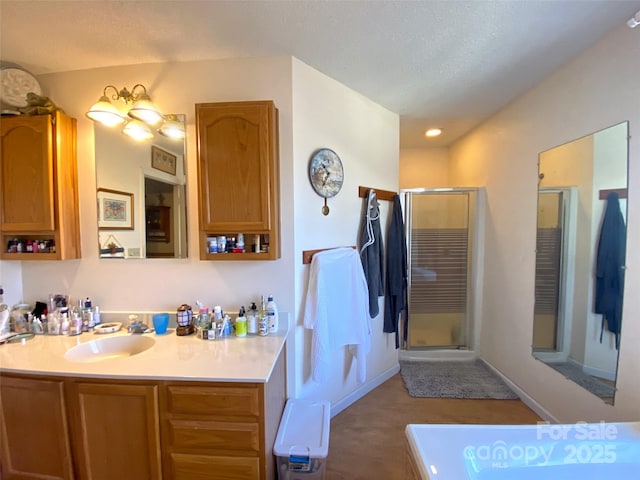 full bathroom featuring a shower stall, baseboards, and vanity