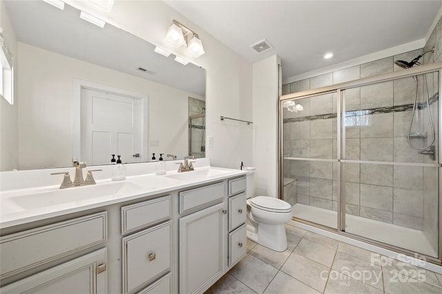 bathroom featuring vanity, toilet, a shower with shower door, and tile patterned flooring