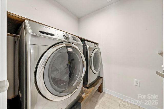 clothes washing area with washing machine and dryer and light tile patterned floors