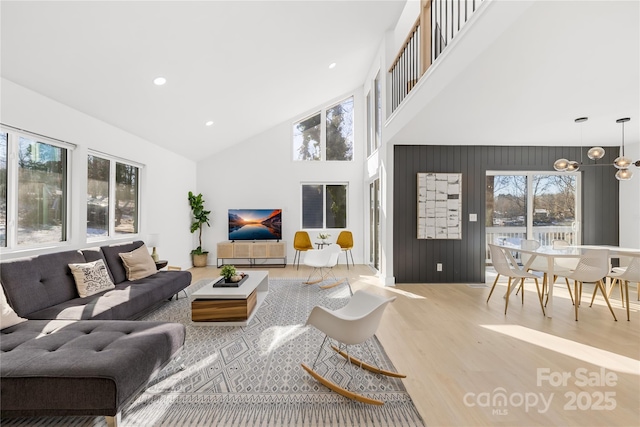 living room featuring a healthy amount of sunlight, high vaulted ceiling, and hardwood / wood-style floors