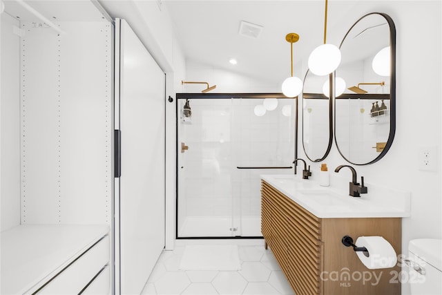 bathroom featuring a shower with door, vanity, tile patterned floors, and toilet