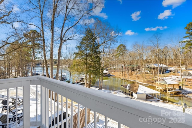 snow covered back of property with a water view