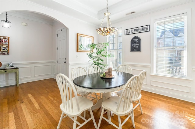 dining space featuring crown molding and light hardwood / wood-style floors