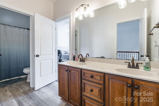 bathroom with hardwood / wood-style flooring, vanity, and toilet