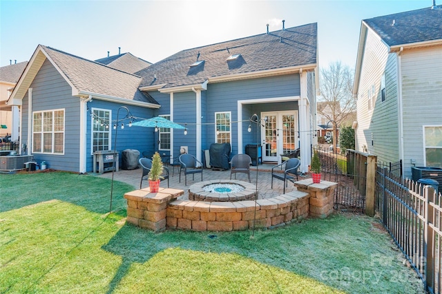 back of house featuring french doors, a patio area, a lawn, and an outdoor fire pit