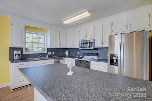 kitchen with white cabinetry, sink, stainless steel appliances, and a textured ceiling