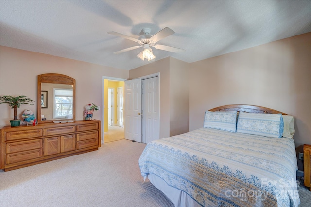 bedroom with ceiling fan, light colored carpet, and a closet