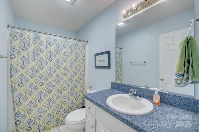 bathroom with vanity, a textured ceiling, and toilet