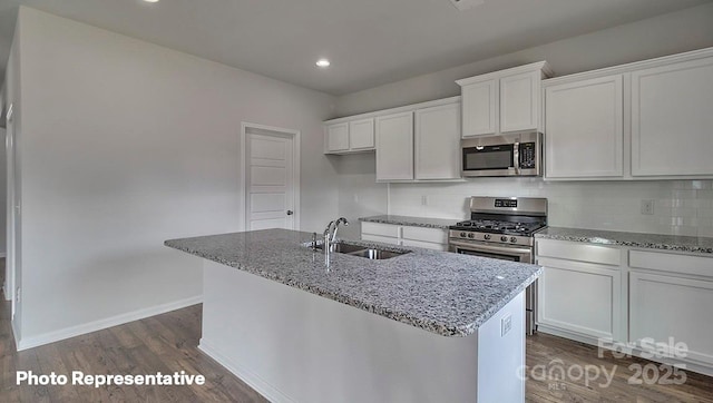 kitchen featuring sink, stainless steel appliances, white cabinets, and a center island with sink