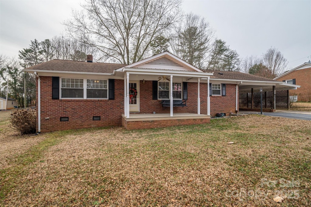 view of front of property with a carport, a porch, and a front lawn